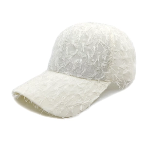 Detailed close-up of white baseball cap featuring unique long fringe tassel fabric texture