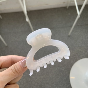 Detail of a large translucent white square hair claw clip held by hand for thick hair