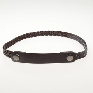 Detail of brown braided rope belt with smooth leather ends and metal buckle accents