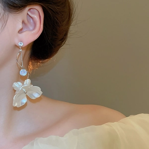 Détail de la boucle d'oreille en argent avec fleur blanche et zircon étincelant