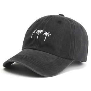 Close-up of coconut tree embroidery on a black washed denim baseball cap with curved brim