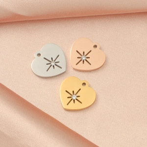 Makroansicht von herzförmigen Stahlanhängern in Silber, Gold und Roségold mit Sternenmotiven