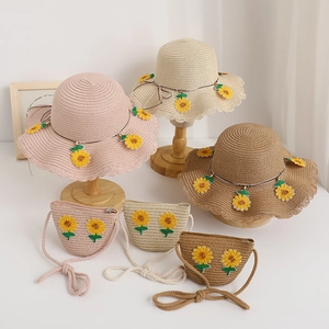 Dettaglio cappello di paglia estivo e borsa a tracolla con girasoli e trama intrecciata