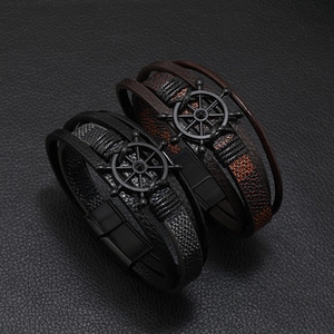 Detail of nautical multi-layer leather bracelet with metal helm charm and magnetic clasp
