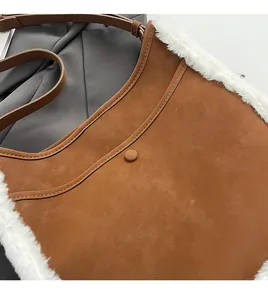 Close-up of brown suede shoulder bag with white faux fur trim and magnetic buckle