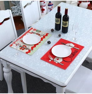 Close-up of red and white Christmas table mats with Santa and stripe patterns
