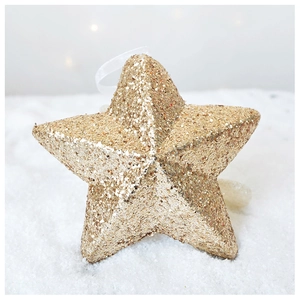 Macro detail of a golden star Christmas tree ornament with glittering texture and white ribbon