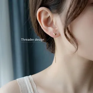 Minimalist gold heart threader earrings showing long chain dangle on female model