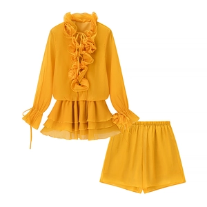 Flat lay of yellow two-piece set featuring ruffled long sleeve top and matching shorts