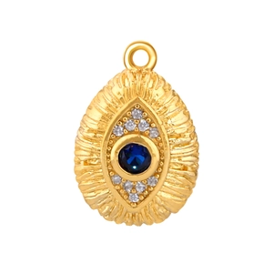 Dettaglio di un ciondolo ovale placcato oro con pietra blu e design malocchio