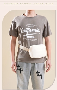 Front view of a white nylon outdoor sports fanny pack worn by a model on plain background