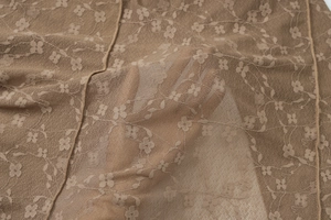 Gros plan sur la dentelle florale marron montrant la transparence et la texture