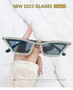 Detailed close-up of cat-eye sunglasses with hand-set rhinestones on black frame
