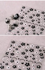 Detail of black and white flower nail stickers with heart and pearl patterns