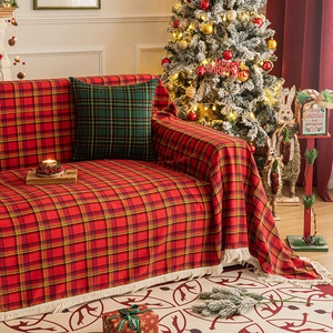 Christmas plaid sofa cover with white tassels in a festive holiday living room setting