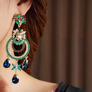 Vue détaillée de boucles d'oreilles vintage dorées avec gemmes vertes et bleues
