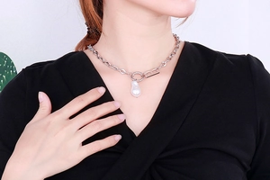 Close-up of a silver baroque pearl necklace with a vintage metal B-shaped clasp
