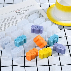 Macro detail of 24-cavity candy silicone mold with colorful striped treats on a grid