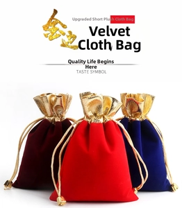 Detail of velvet drawstring jewelry pouches in red, wine, and blue with gold trim