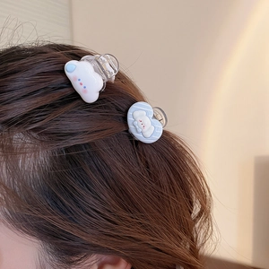 Détail de pinces à cheveux nuage bleu et nœud portées sur des cheveux bruns