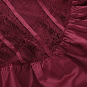 Détail macro de la robe bordeaux avec dentelle épissée et texture en satin lisse