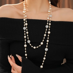 Detail of layered pearl necklace with tiger eye beads on black knit sweater