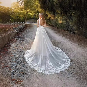 Elegant white lace wedding dress featuring a deep V-back design and long train detail