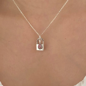 Detailed close-up of a 925 silver padlock pendant with pink gemstone on a cable chain