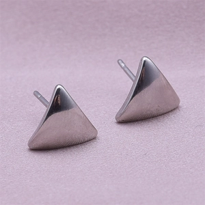 Detail view of triangular 304 stainless steel stud earrings on soft purple fabric