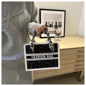 Detail of leopard print canvas tote bag with silk scarf on handle and Fashion Bag text