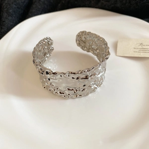 Detailed macro view of the silver open bangle with artistic hammered lava texture