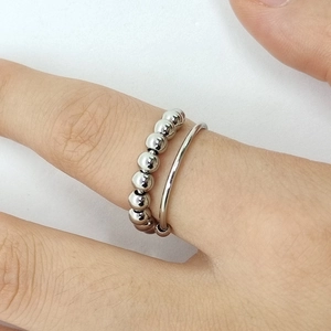 Minimalist stainless steel spinner ring with movable beads for anxiety relief on finger