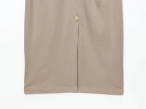 Detail von khakifarbenem Twill-Stoff und goldenem Prägeknopf am Saum des Kleides