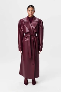 Vue d'ensemble d'un trench-coat long élégant en similicuir bordeaux avec ceinture taille