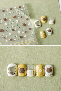 Detail of sweet bear and daisy 3D nail stickers with embossed texture on green background