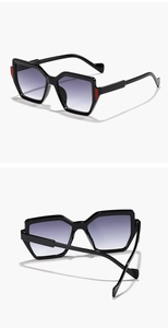 Detail of polygonal sunglasses with gradient purple lenses and red hinge accents