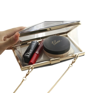 Transparent acrylic evening clutch bag with gold metal frame and detachable chain strap