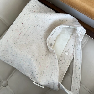 Dettaglio della borsa tote in tela con puntini colorati e tasca interna con chiusura magnetica