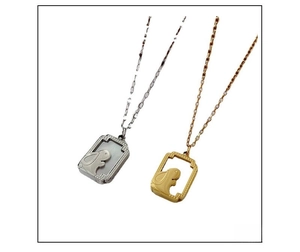 Detail of bunny pendants in gold and silver finish with white shell inlay and fine chain