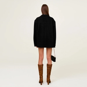 Back view of a long oversized black denim jacket with a classic cross design on the back
