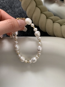 Detail of natural freshwater pearl bracelet with gold beads and elegant metal clasp