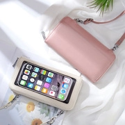 Pink and beige crossbody phone bags with touch screen window on soft fabric background