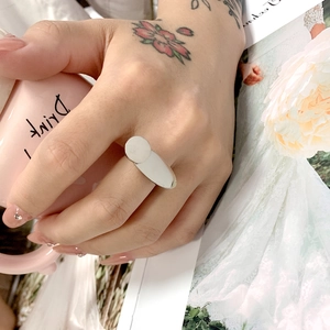 Close-up of a minimalist silver titanium steel ring worn while holding a pink cup