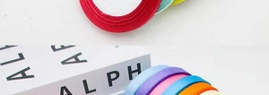 Macro detail of vibrant 1cm satin ribbon rolls in assorted colors for gift wrapping