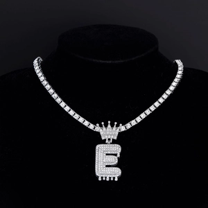Vista macro del pendente a lettera E con corona hip-hop argentata e diamanti luccicanti