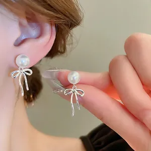Elegante silberne Schleifenohrringe mit weißen Perlen für einen raffinierten Damen-Look