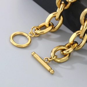 Macro shot of gold stainless steel Cuban chain bracelet with OT toggle clasp detail