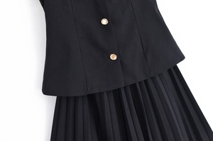 Détails d'un blazer noir à boutons dorés et d'une jupe plissée pour femmes