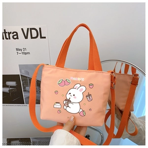 Detail of orange canvas bag featuring a cute rabbit print and matching shoulder strap