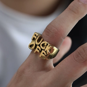 Detailed view of vintage gold-plated titanium steel ring with embossed bold lettering